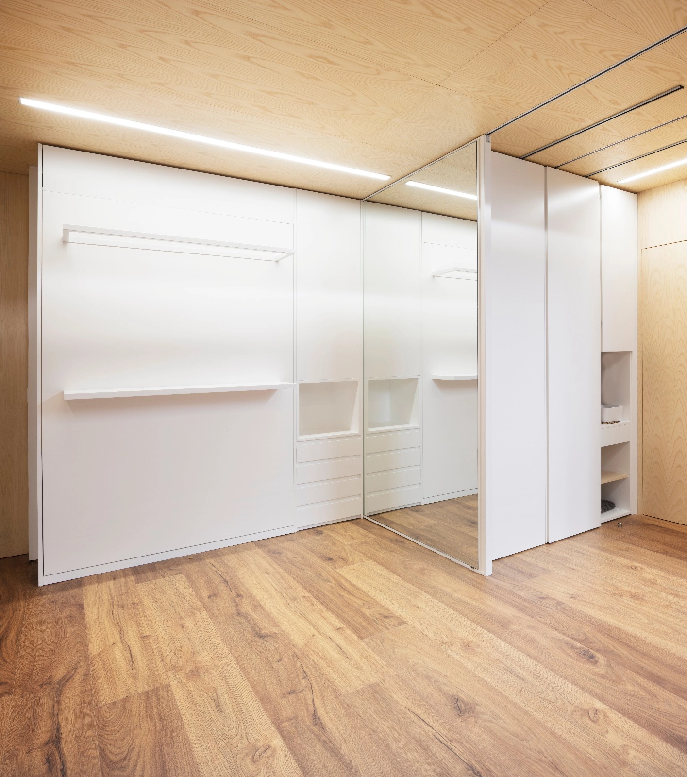 Cama oculta tras paneles móviles en un dormitorio transformable | E6A